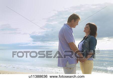 Couple holding hands on beach View Large Photo Image Stock Photograph - Couple holding hands on beach. Fotosearch