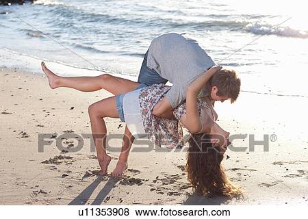 Stock Photo - Couple playing together on beach. Fotosearch