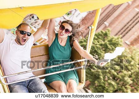 Stock Photo - Couple riding amusement park ride. Fotosearch
