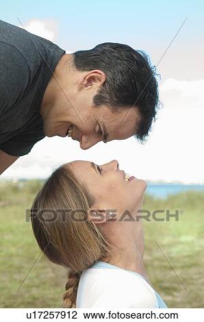 Stock Image - Couple smiling at each other outdoors. Fotosearch