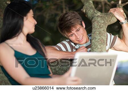 Couple using laptop outdoors View Large Photo Image Picture - Couple using laptop outdoors. Fotosearch