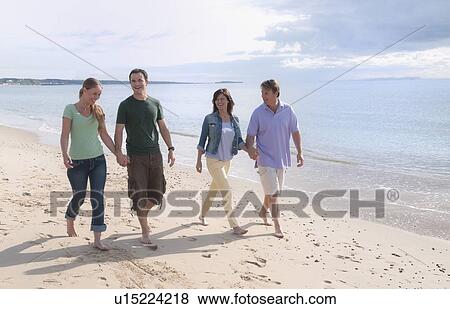 Couples holding hands on beach View Large Photo Image Stock Photo - Couples holding hands on beach. Fotosearch