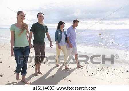 Couples holding hands on beach View Large Photo Image Stock Photograph - Couples holding hands on beach. Fotosearch