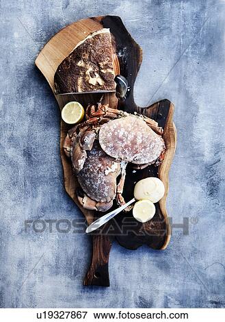 Stock Photo - Cutting board with crab and lemon. Fotosearch