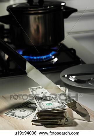 Stock Photograph - Dollar bills in frying pan on stove. Fotosearch