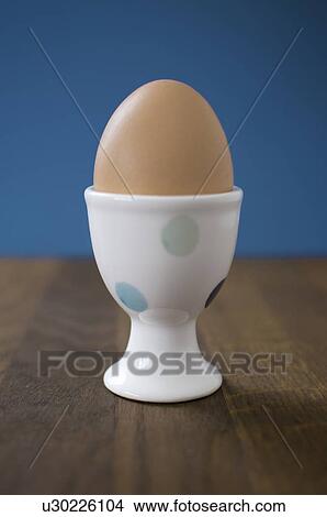 Egg in egg cup on table View Large Photo Image Picture - Egg in egg cup on table. Fotosearch