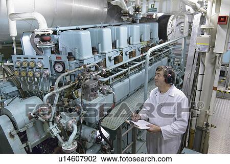 Stock Image - Engineer working in ships engine room. Fotosearch