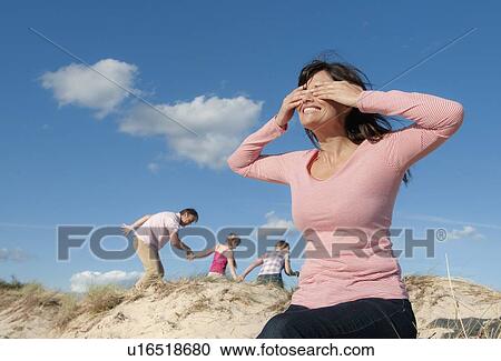 Family playing hide and seek outdoors View Large Photo Image Stock Image - Family playing hide and seek outdoors. Fotosearch