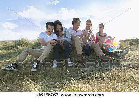 Stock Image - Family relaxing together outdoors. Fotosearch