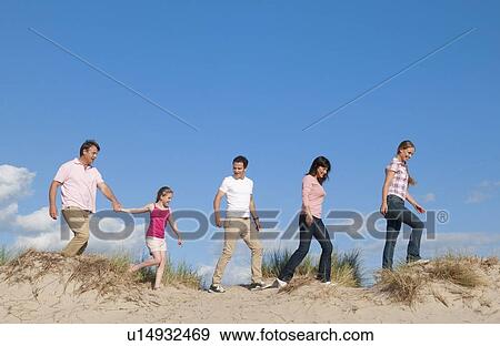 Family walking together on sand dune View Large Photo Image Stock Photo - Family walking together on sand dune. Fotosearch