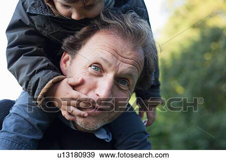 Stock Photo - Father carrying son on his shoulders. Fotosearch