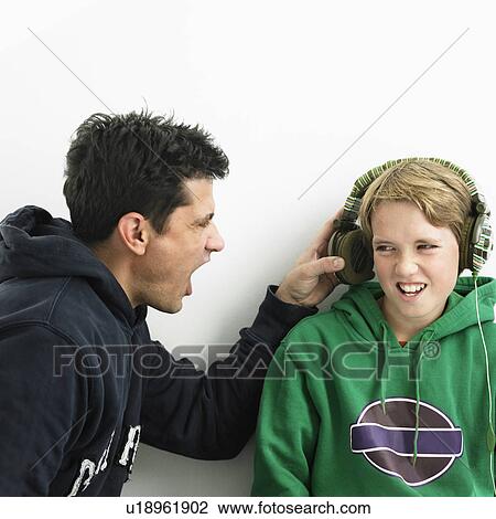 Father shouting into boys earphones View Large Photo Image Stock Image - Father shouting into boys earphones. Fotosearch