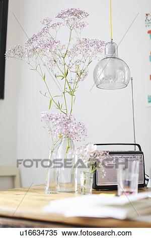 Stock Photography - Flowers, radio and water glass on table. Fotosearch