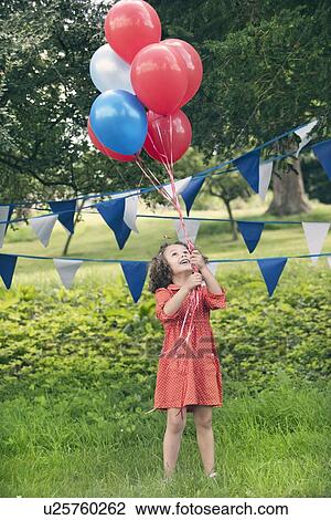 Girl holding bunch of balloons outdoors View Large Photo Image Stock Image - Girl holding bunch of balloons outdoors. Fotosearch