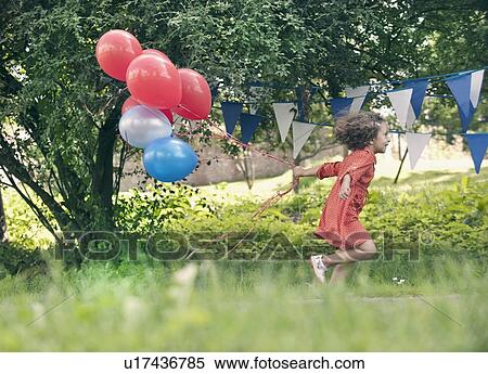 Girl holding bunch of balloons outdoors View Large Photo Image Stock Photography - Girl holding bunch of balloons outdoors. Fotosearch