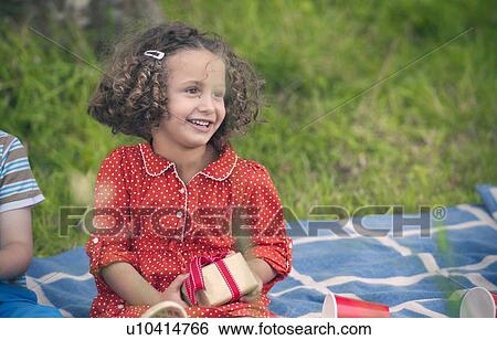 Girl holding gift at birthday picnic View Large Photo Image Stock Photograph - Girl holding gift at birthday picnic. Fotosearch