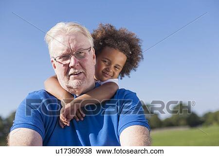 Girl hugging grandfather outdoors View Large Photo Image Stock Photo - Girl hugging grandfather outdoors. Fotosearch