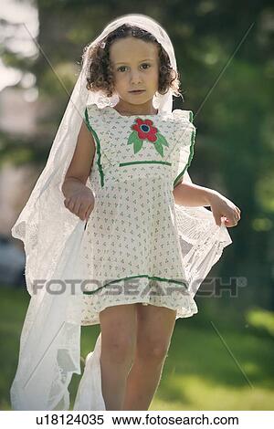 Stock Photography - Girl playing with veil in garden. Fotosearch