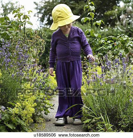 Stock Photograph - Girl walking in garden outdoors. Fotosearch