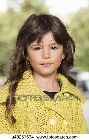 Picture - Girl wearing yellow sweater outdoors. Fotosearch