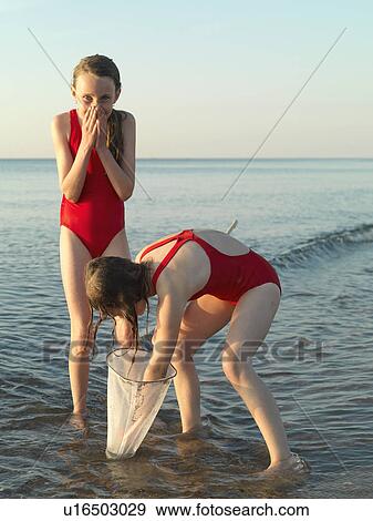 Girls fishing in shallow water View Large Photo Image Stock Photo - Girls fishing in shallow water. Fotosearch