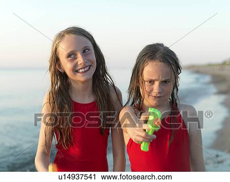 Stock Image - Girls playing on beach together. Fotosearch