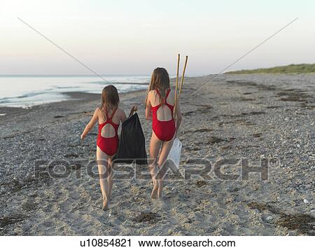 Girls walking on sandy beach View Large Photo Image Stock Image - Girls walking on sandy beach. Fotosearch