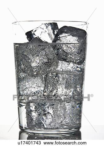 Stock Image - Glass of ice cubes in fizzy drink. Fotosearch