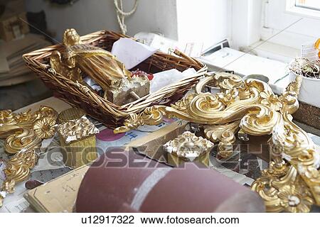 Stock Image - Gold embellishments on work table. Fotosearch