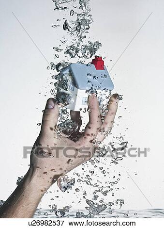 Hand grasping model house in water View Large Photo Image Stock Photo - Hand grasping model house in water. Fotosearch