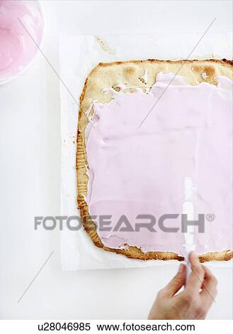 Stock Photography - Hand spreading cream on bread. Fotosearch