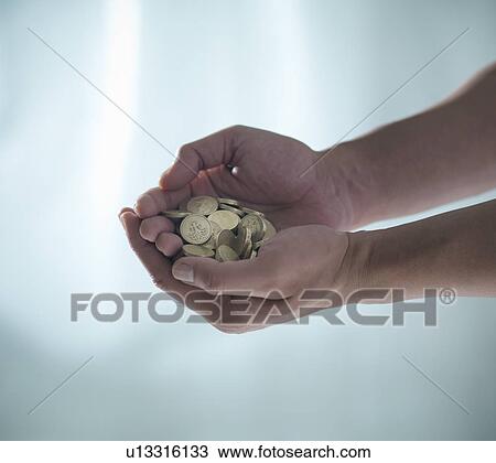 Stock Image - Hands holding pile of coins. Fotosearch