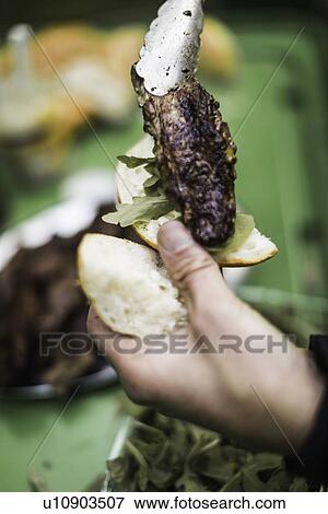 Hands placing sausage on bun View Large Photo Image Stock Photo - Hands placing sausage on bun. Fotosearch