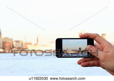 Stock Image - Hands taking picture with cell phone. Fotosearch