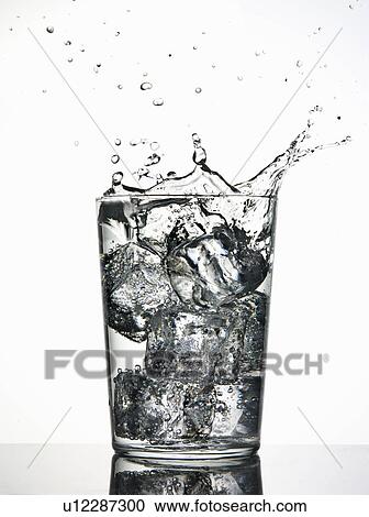 Stock Image - Ice cubes splashing into fizzy drink. Fotosearch