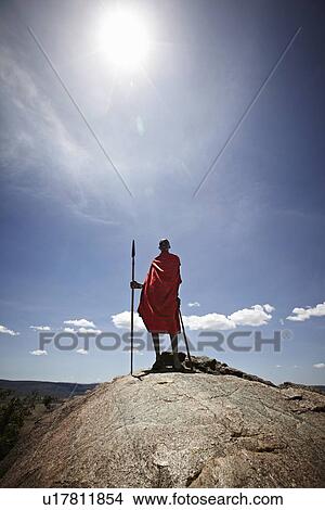 Maasai man standing on top of rock View Large Photo Image Picture - Maasai man standing on top of rock. Fotosearch