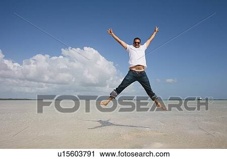 Man jumping in water on tropical beach View Large Photo Image Stock Image - Man jumping in water on tropical beach. Fotosearch