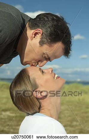 Man kissing girlfriend outdoors View Large Photo Image Stock Image - Man kissing girlfriend outdoors. Fotosearch