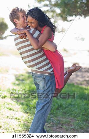 Man lifting girlfriend outdoors View Large Photo Image Picture - Man lifting girlfriend outdoors. Fotosearch