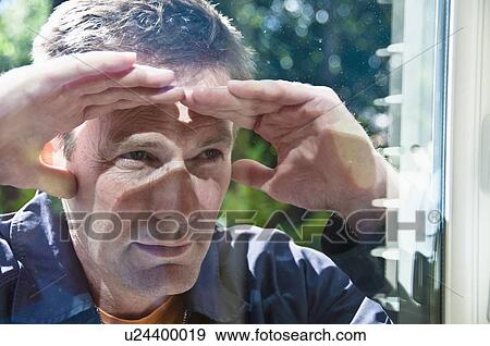 Man peering in window of house View Large Photo Image Stock Photo - Man peering in window of house. Fotosearch