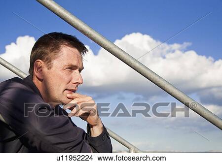 Picture - Man sitting on steps outdoors. Fotosearch