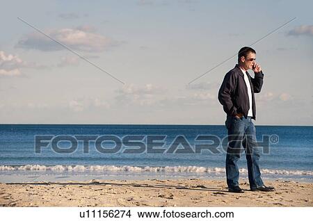 Man talking on cell phone on beach View Large Photo Image Picture - Man talking on cell phone on beach. Fotosearch