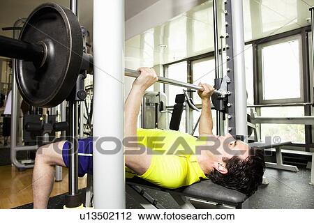 Man using exercise equipment at gym View Large Photo Image Stock Image - Man using exercise equipment at gym. Fotosearch