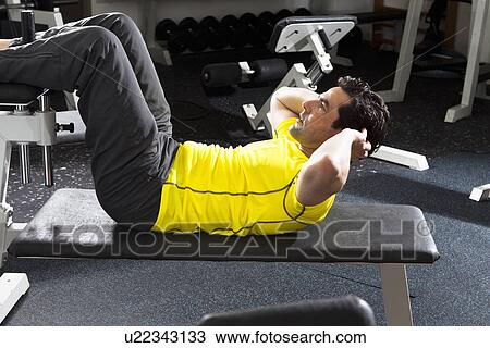 Man using exercise equipment at gym View Large Photo Image Stock Image - Man using exercise equipment at gym. Fotosearch