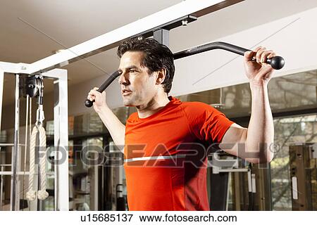 Man using exercise equipment at gym View Large Photo Image Stock Photo - Man using exercise equipment at gym. Fotosearch