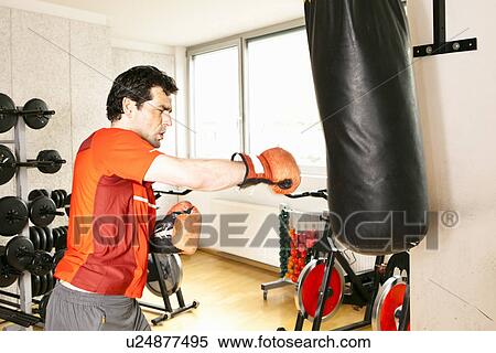 Man using punching bag at gym View Large Photo Image Stock Photography - Man using punching bag at gym. Fotosearch