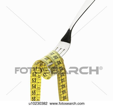 Stock Image - Measuring tape coiled on fork. Fotosearch
