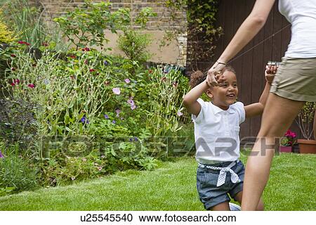 Mother and daughter dancing in garden View Large Photo Image Stock Image - Mother and daughter dancing in garden. Fotosearch