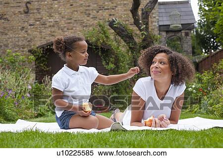 Mother and daughter eating in backyard View Large Photo Image Stock Photography - Mother and daughter eating in backyard. Fotosearch