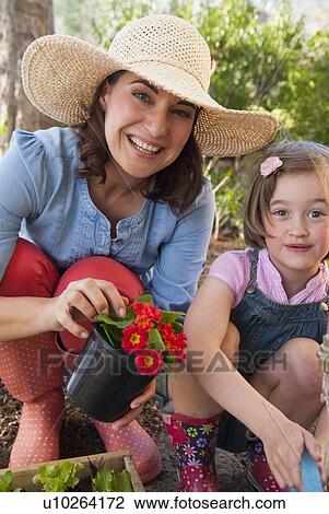 Mother and daughter gardening together View Large Photo Image Stock Image - Mother and daughter gardening together. Fotosearch